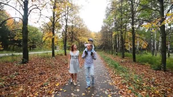 Feliz paseo familiar sonriente en el parque de otoño — Vídeo de stock