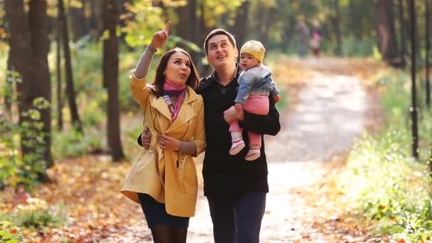 Familia feliz en el paseo por el parque en el otoño — Vídeo de stock