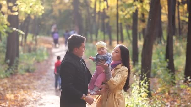 Família feliz em passeio no parque no outono — Vídeo de Stock