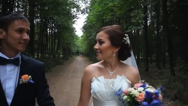 Mooie bruid en bruidegom lopen in het voorjaar forest — Stockvideo