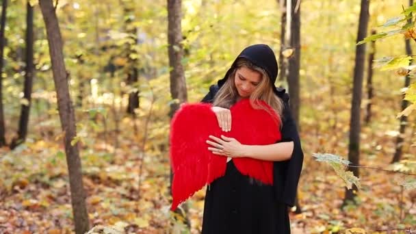 Hermosa chica con alas de ángel rojo en el bosque — Vídeos de Stock