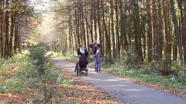 Familjen promenader längs hösten väg — Stockvideo