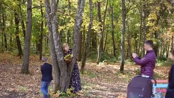 Herfst scène van jonge en gelukkige familie nemen selfies met haar smartphone in het park — Stockvideo