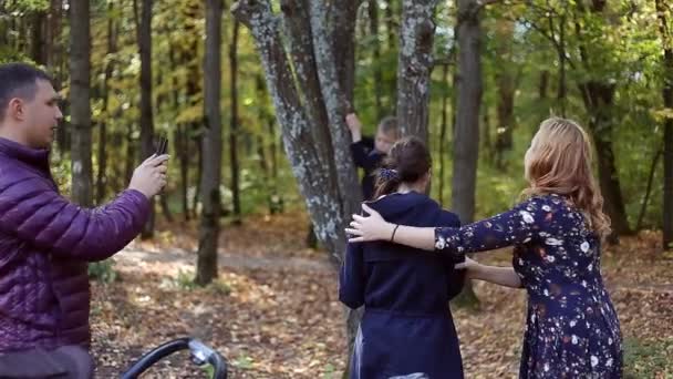 Escena otoñal de la joven familia feliz tomando selfies con su smartphone en el parque — Vídeo de stock