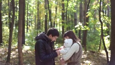 Çocuklu aile sonbahar parkına gider.