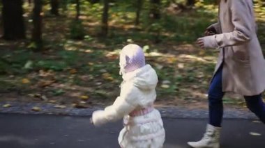 Anne ve çocuk parkta yürüyor.