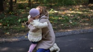 Anne ve çocuk parkta yürüyor.