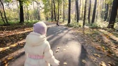 Anne ve çocuk parkta yürüyor.