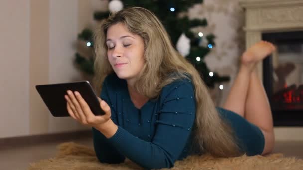 Jonge vrouw alleen, zit kerstboom en het gebruik van ingediend — Stockvideo