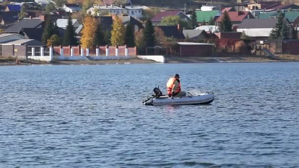 Um pescador em um barco a motor de pesca — Vídeo de Stock