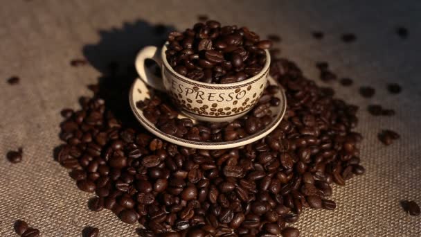 Une tasse avec des grains de café comme fond — Video