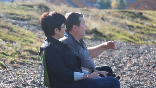 Ältere Liebhaber sitzen am Strand und genießen die Aussicht — Stockvideo