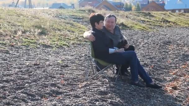 Ältere Liebhaber sitzen am Strand und genießen die Aussicht — Stockvideo