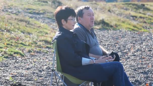 Ältere Liebhaber sitzen am Strand und genießen die Aussicht — Stockvideo