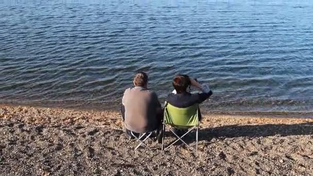 成熟的恋人坐在海滩和欣赏美景 — 图库视频影像