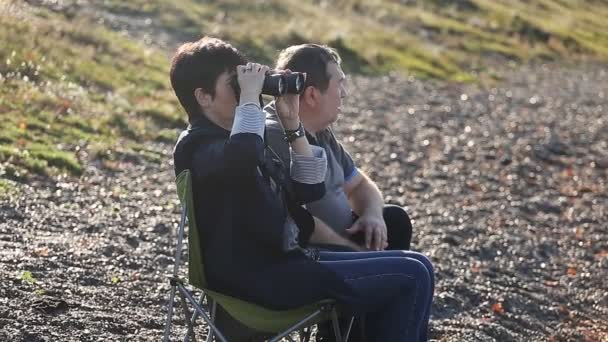 Volwassen liefhebbers zit op het strand en genieten van het uitzicht — Stockvideo