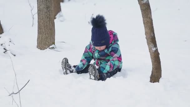 Маленькая девочка играет со снегом — стоковое видео