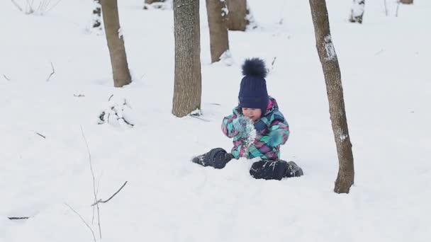 Klein meisje spelen met sneeuw — Stockvideo