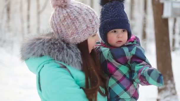 Mãe feliz segurando bebê menina no passeio no inverno floresta nevada — Vídeo de Stock