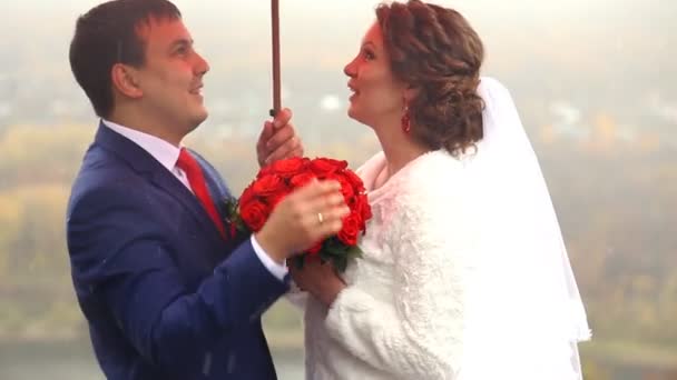 Casamento casal segurando guarda-chuva vermelho — Vídeo de Stock