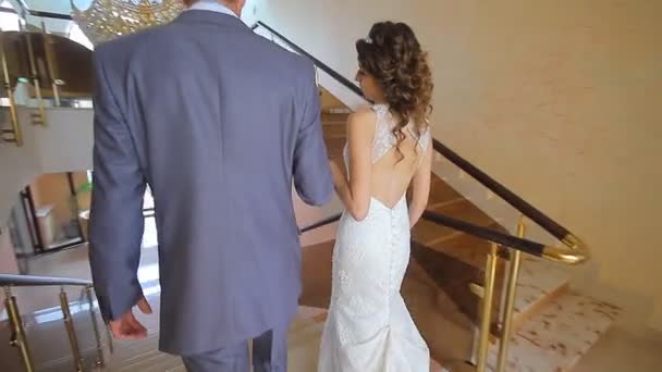 Elegáns, elegáns fiatal pár gyönyörű menyasszony és vőlegény a lépcsőn — Stock videók