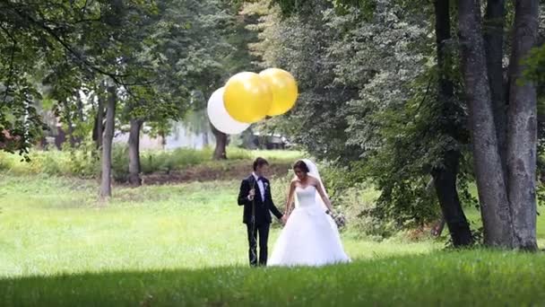 Recién casados sosteniendo bolas de blanco y amarillo — Vídeos de Stock