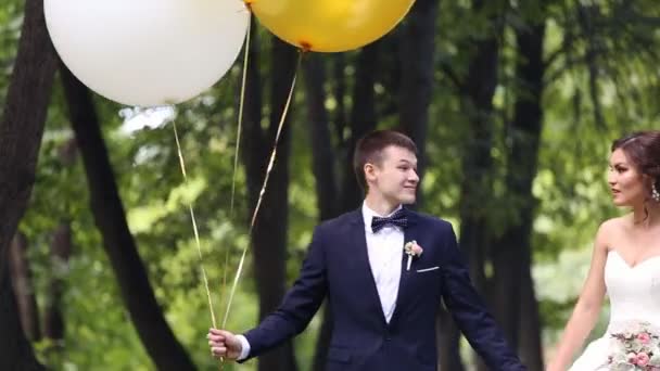 Recién casados sosteniendo bolas de blanco y amarillo — Vídeo de stock