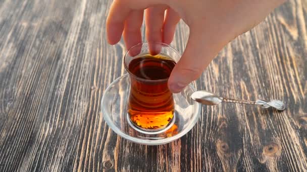 Ahşap bir masa üzerinde bir bardağa çay dökme — Stok video