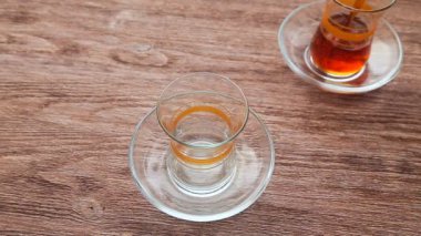 Ahşap bir masa üzerinde bir bardağa çay dökme