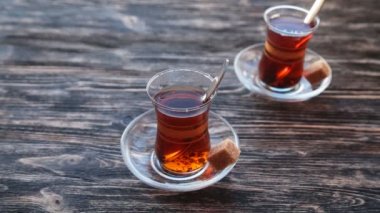Ahşap bir masa üzerinde bir bardağa çay dökme