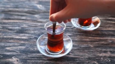 Ahşap bir masa üzerinde bir bardağa çay dökme