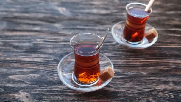 Налить чай в чашку на деревянный стол — стоковое видео