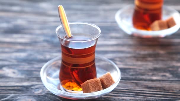 Gieten van thee in een beker op een houten tafel — Stockvideo