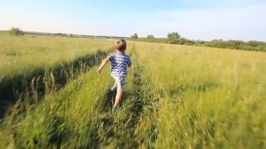 Boy running across hill in slowmotion