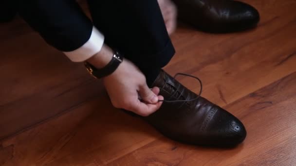 Zamknij się człowiek nogi i ręce wiązanie sznurówki do butów — Wideo stockowe