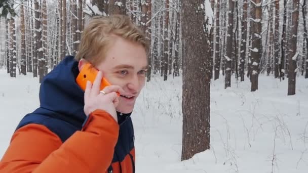 Um homem a falar ao telefone no parque em câmara lenta — Vídeo de Stock