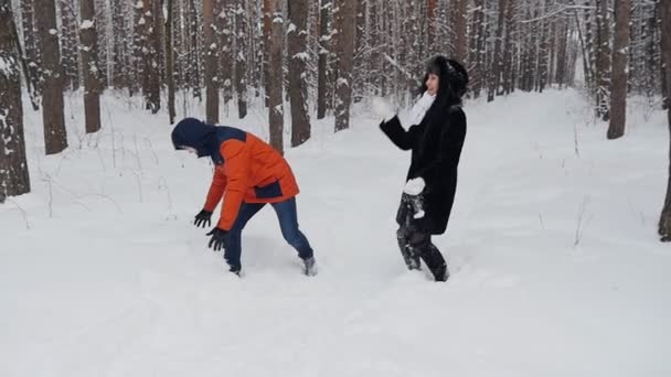 Paar in het park in de winter werpt sneeuw in slowmotion — Stockvideo