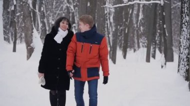 Genç hippi çift slowmotion kış ormanda yürüyüşe sahip