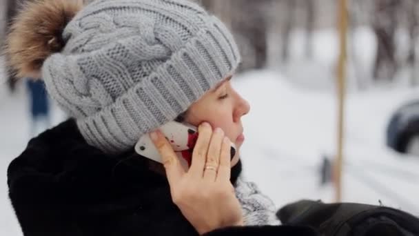 Kız kış telefon Park ve gülümseyerek — Stok video