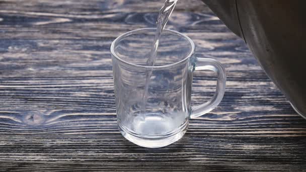 Glass of tea with teabag and pouring water in slowmotion — Αρχείο Βίντεο