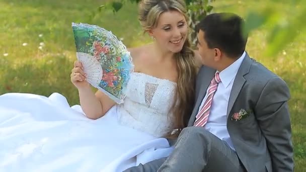 Bruid en bruidegom zitten — Stockvideo