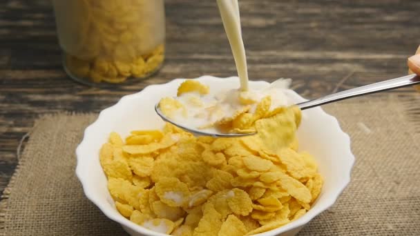 Fresh milk pouring into a bowl full of cornflakes in slowmotion — Stock Video