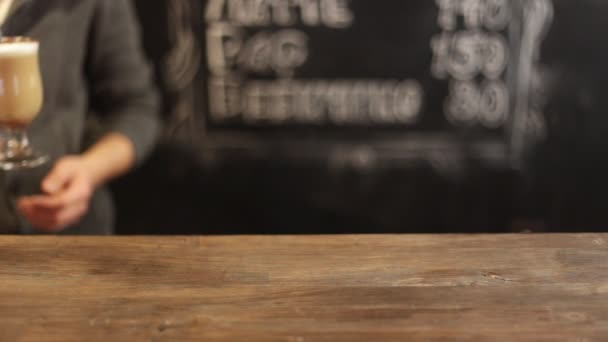 Barista βάζοντας φλιτζάνι καφέ κάτω στον πάγκο σε ένα καφέ — Αρχείο Βίντεο