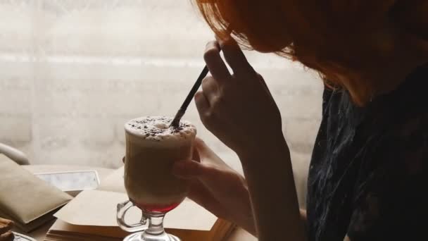 Mujer leyendo libro y tomando café en la cafetería — Vídeo de stock