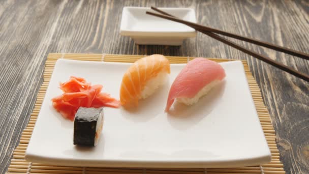 Leckeres Maki-Sushi in einen Teller geben — Stockvideo