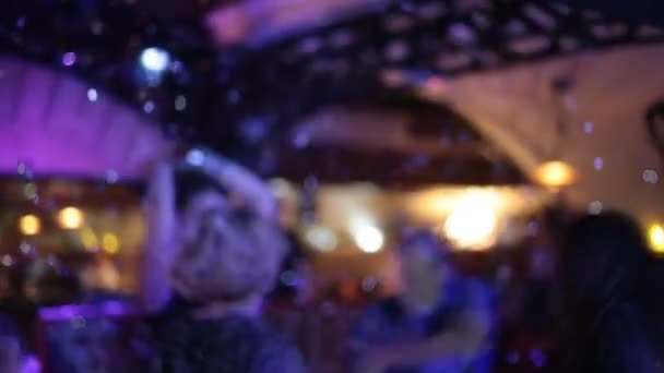 La gente baila en la fiesta en el club nocturno con luz de color, desenfocada — Vídeo de stock