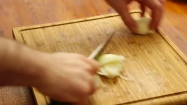 elinde soğan doğrama tahtası üzerinde kesme