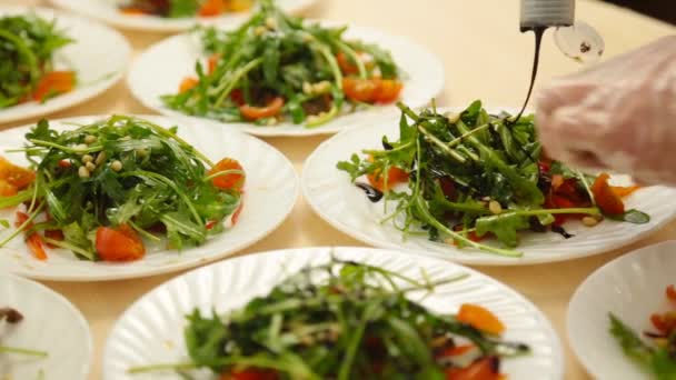 Manos de chef masculino sirviendo ensalada en el plato — Vídeo de stock