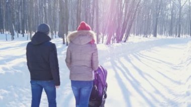 Mutlu genç aile kışın parkta yürüyüş