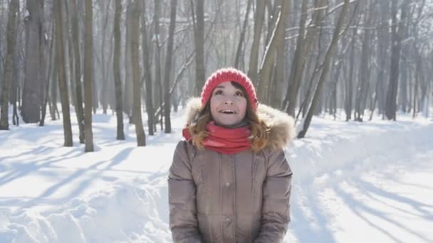 幸せな若い女が公園、スローモーションで雪をスローします。 — ストック動画